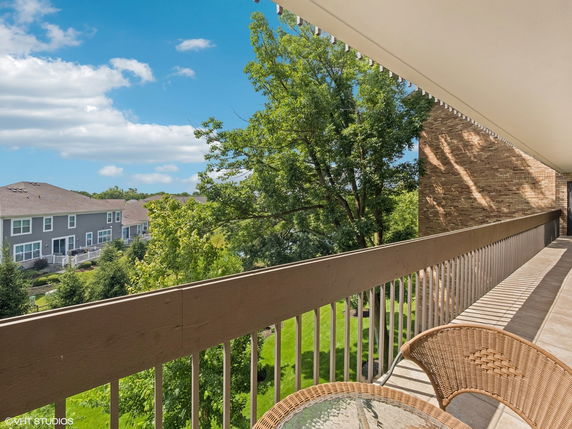 Panoramic view from a balcony overlooking houses and greenery.