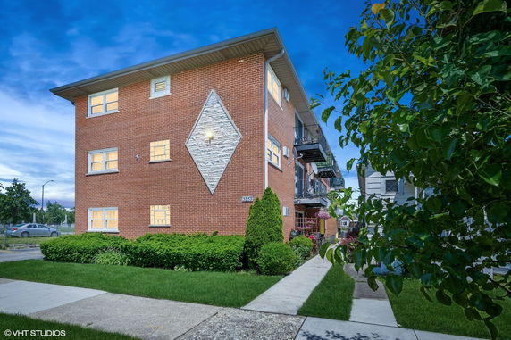 Front view of a multi-story brick building with balconies on the side.