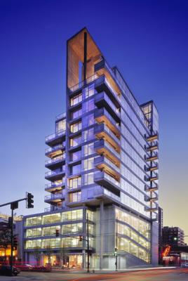Front view of a multi-story modern building with large glass windows and balconies.