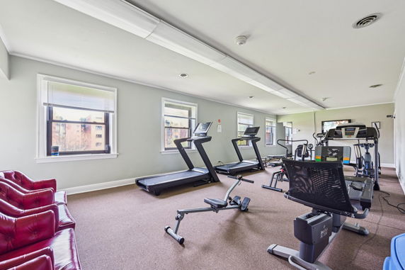 Indoor gym area with fitness equipment including treadmills and stationary bikes.