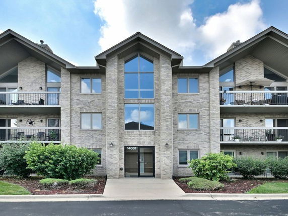 Front view of a multi-story apartment building with balconies.