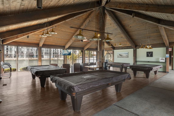 Recreational room with pool tables and seating area.