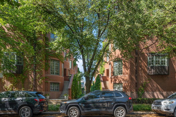 Front view of a brick residential building with multiple floors and bay windows.
