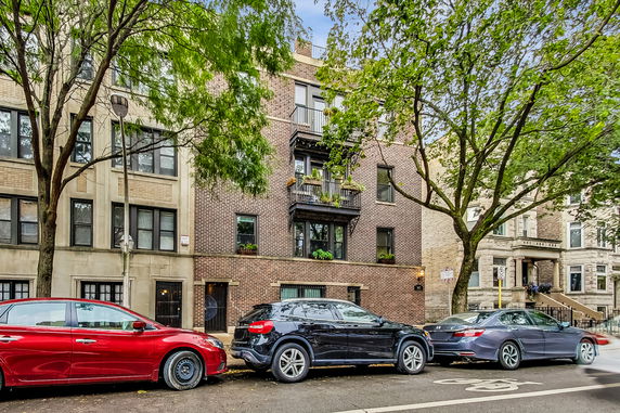 Front view of a multi-story brick building with balconies.