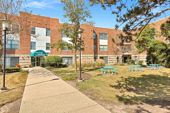 Front view of a multi-story building with a pathway and lawn area.