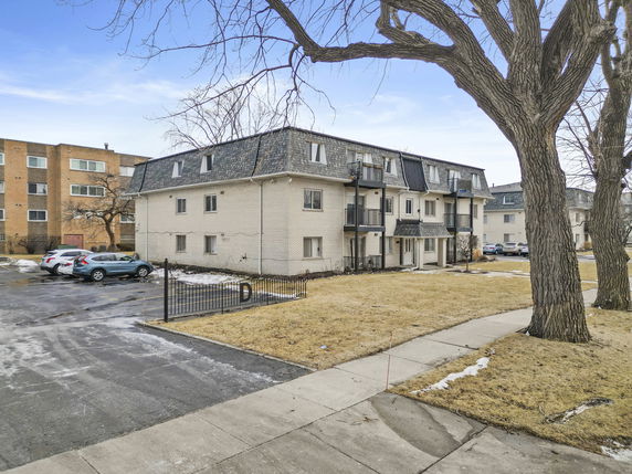 Front view of a multi-story apartment building with small balconies.