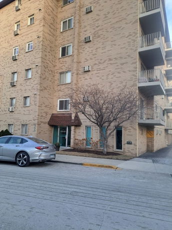 Front view of a multi-story apartment building with balconies.