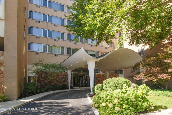 Front view of a multi-story building with a unique curved canopy entrance.