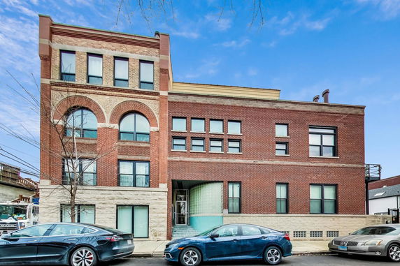 Front view of a multi-story brick building with arched windows.