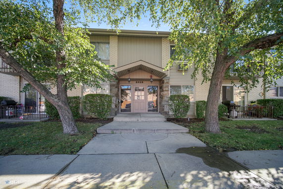 Front view of a two-story building with brick and siding.
