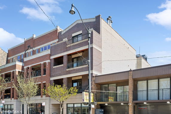 Front view of a multi-story brick building with balconies.