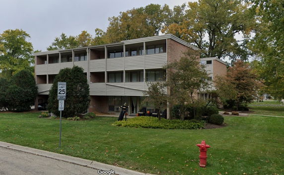 Front view of a three-story apartment building with balconies.