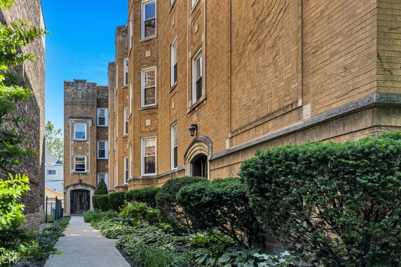View of a brick apartment building with multiple stories and rectangular windows.