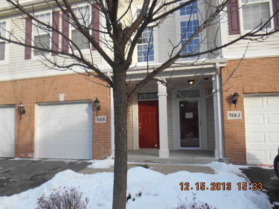 Front view of a two-story house with red front door and dual garages.