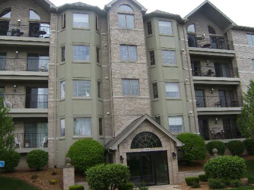 Front view of a multi-story building with balconies and large windows.