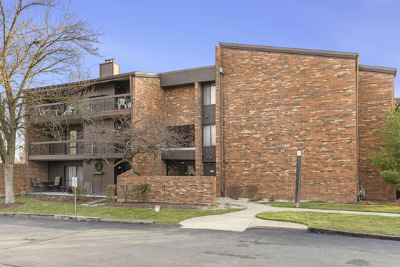 Front view of a brick multi-story building with balconies.