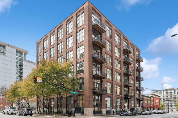 Front view of a multi-story brick building with balconies.