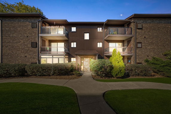 Front view of a three-story apartment building with balconies.