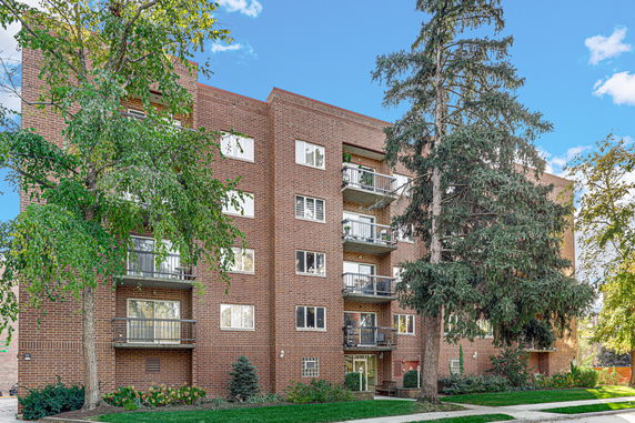 Front view of a multi-story brick apartment building with balconies.