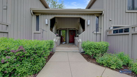 Front view of a house with a recessed entryway and red door.