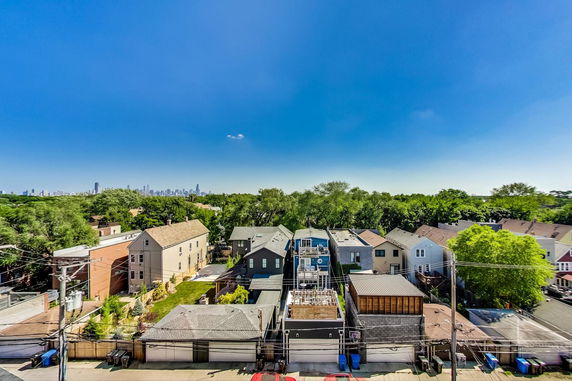 Panoramic view of a suburban area with multiple houses and city skyline in the background.
