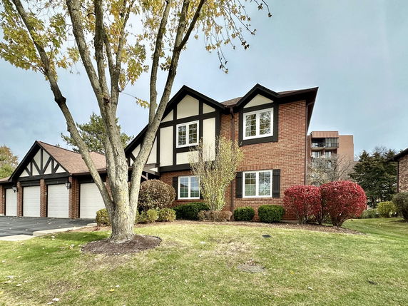 Front view of a two-story brick house with a multi-car garage.
