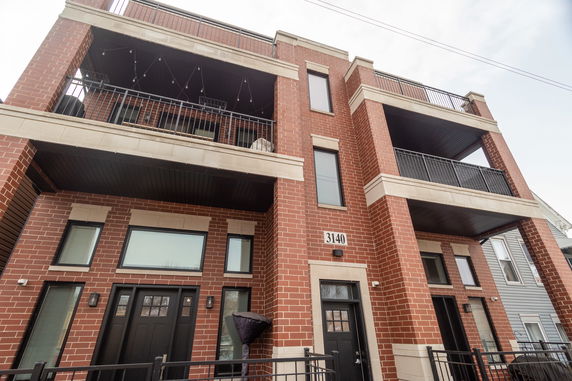Front view of a multi-story brick building with balconies.