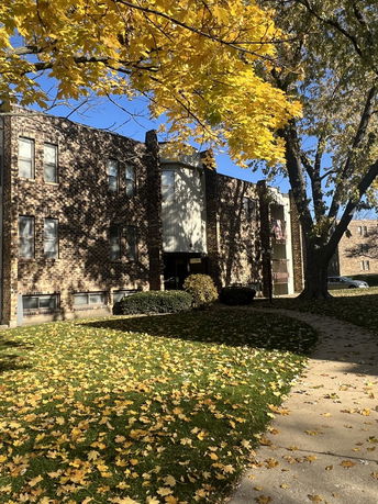 Front view of a multi-story brick building with large windows.