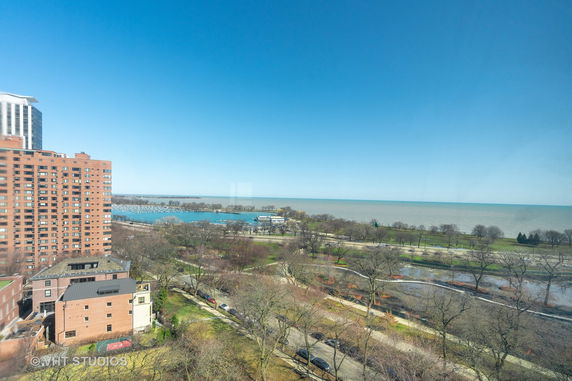Wide angle view of buildings and a body of water in the background.