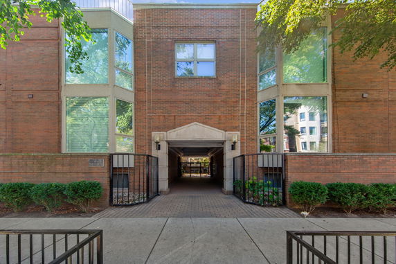 Front view of a multi-story building with large windows and a central entranceway.