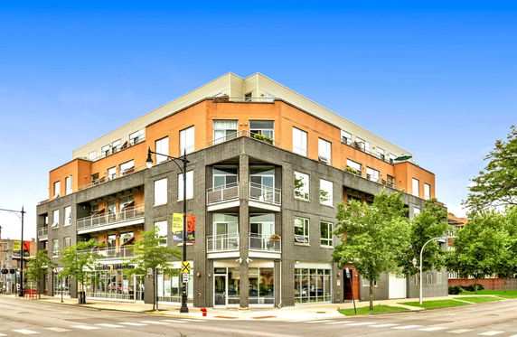 Front view of a multi-story building with brick and glass facade.