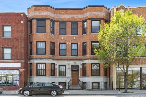 Front view of a multi-story brick building with multiple windows.