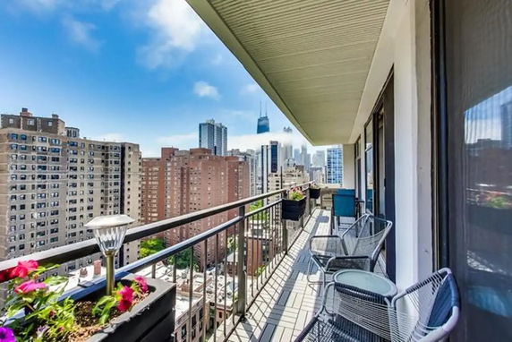 Panoramic view of city buildings from a balcony.