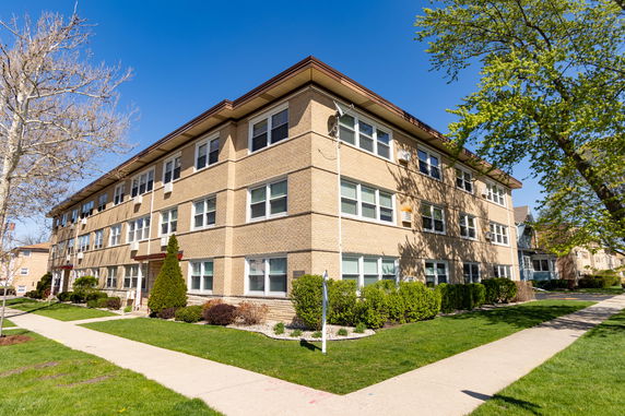Front view of a three-story apartment building with a brick exterior.