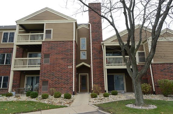 Front view of a multi-story building with brick facade and balconies.