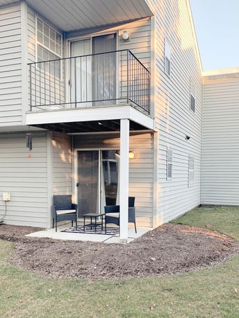 Front view of a two-story house with a balcony and patio area.