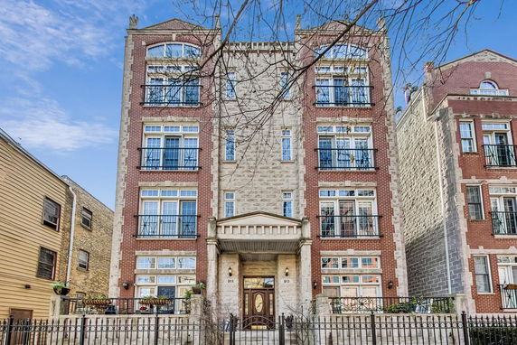 Front view of a multi-story residential building with brick and stone facade.