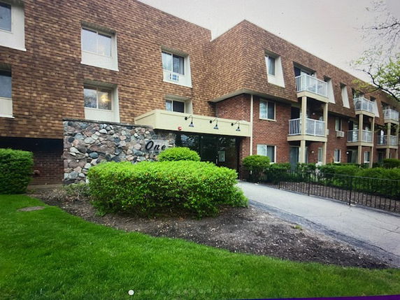 Front view of a multi-story building with brick and stone facade.