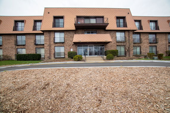 Front view of a multi-story apartment building with a brick facade.
