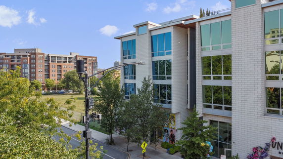 Front view of a modern multi-story building with large windows.