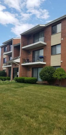 Front view of a three-story apartment building with balconies.