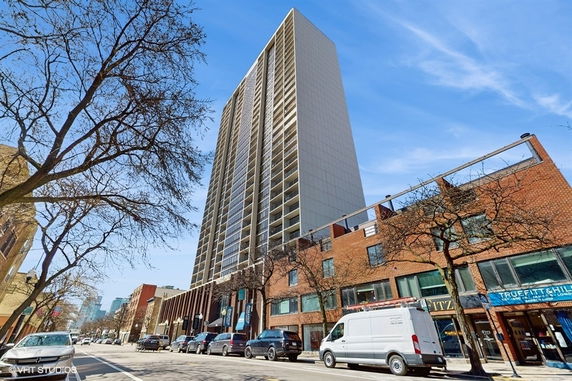 Front view of a tall high-rise building with multiple balconies.