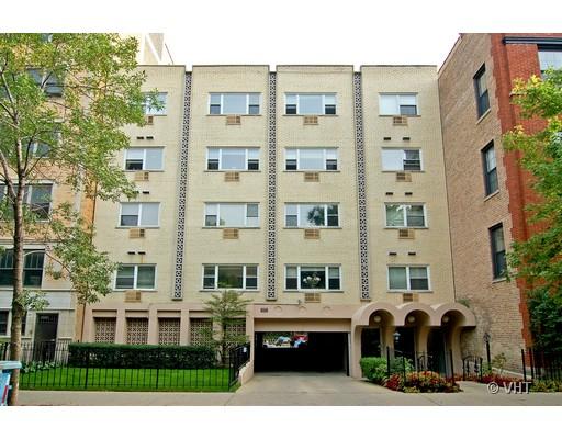 Front view of a four-story apartment building with a central entrance and a garage.