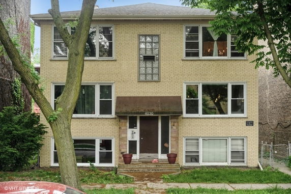 Front view of a three-story brick building with multiple windows.