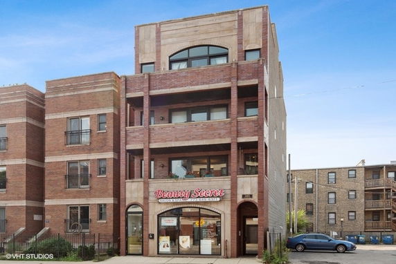 Front view of a multi-story building with a salon on the ground floor.