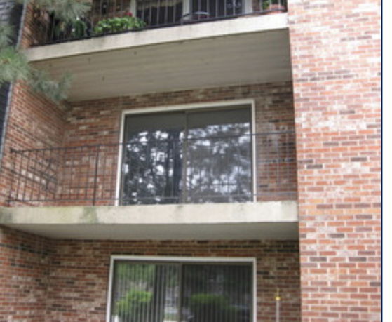 Front view of a multi-story brick building with balconies.