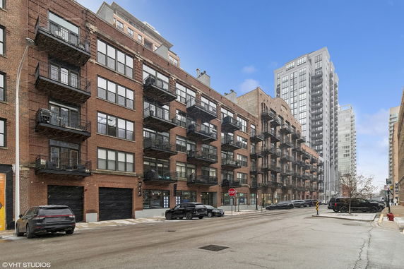 Front view of a multi-story brick apartment building with balconies.