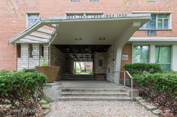 Front view of a brick building with stone and concrete entryway.
