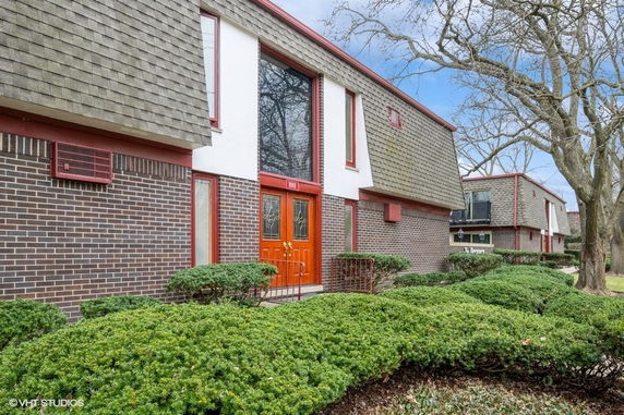 Front view of a two-story building with brick exterior and shingle siding.