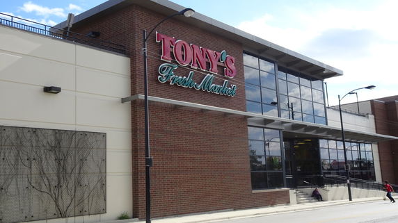 Front view of a commercial building with large glass windows and brick facade.